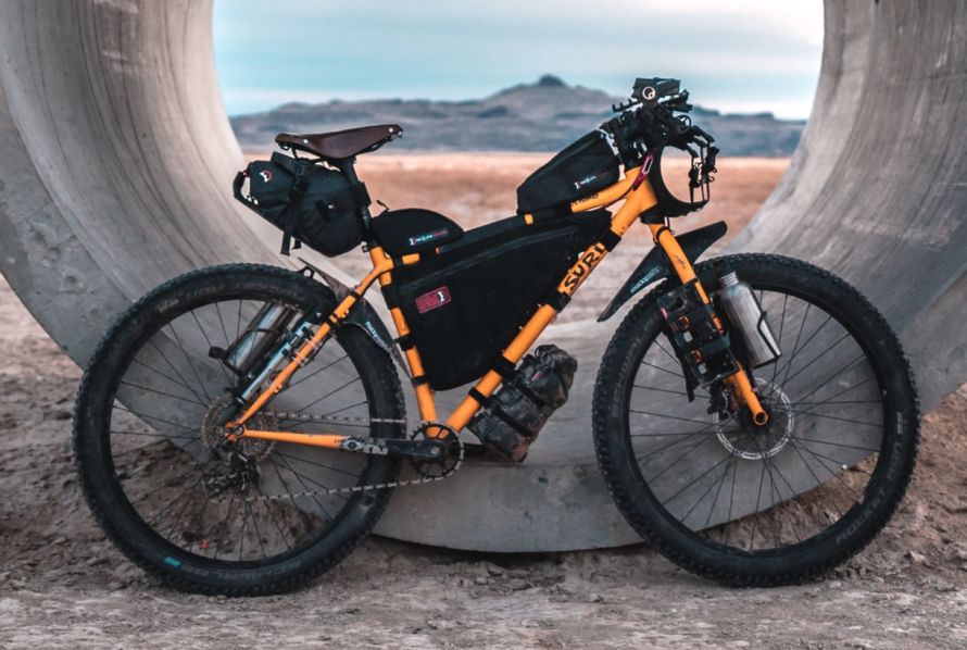 A yellow mountainbike fully loaded with bags for a bikepacking adventure