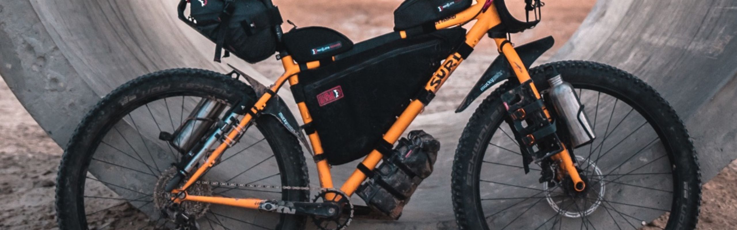 A yellow mountainbike fully loaded with bags for a bikepacking adventure
